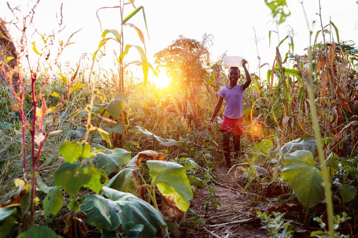 Child running in crops with clean water