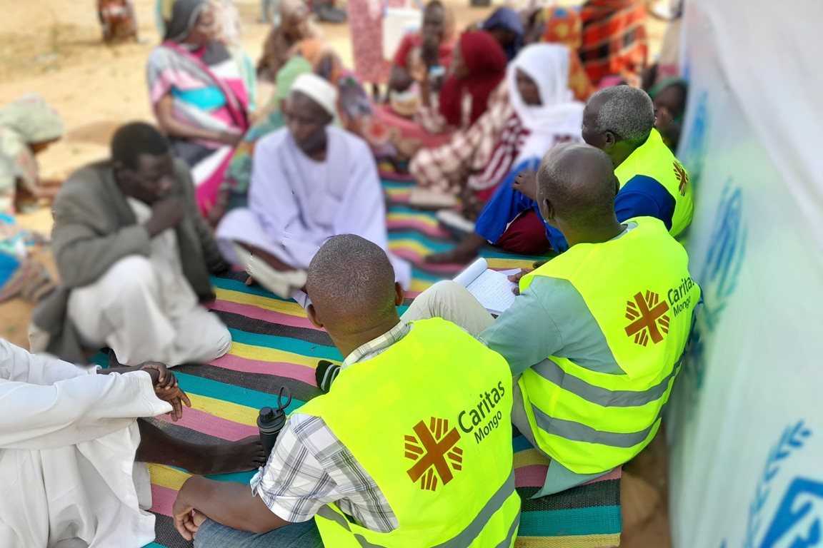 Aid Workers Sit With Sudanese Refugees In Chad Photo Credit Caritas Mongo