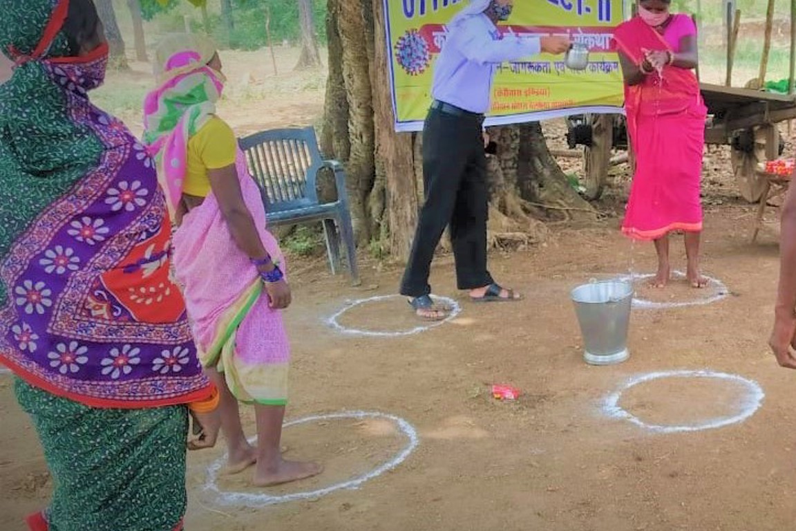 People Social Distancing Near a Handpump in India