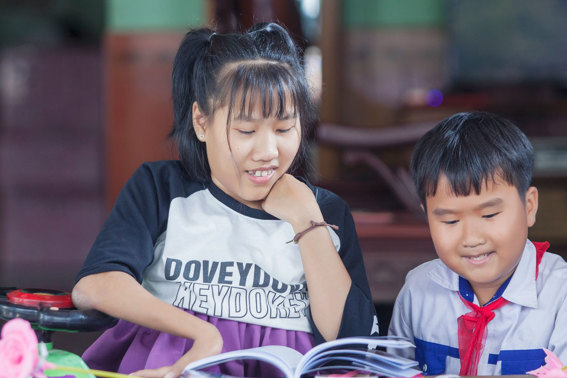 Two Siblings Reading Together In Vietnam