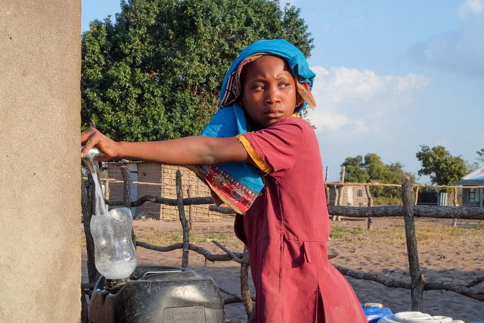 Anatercia collects water from the  community water tap near her house in Mozambique