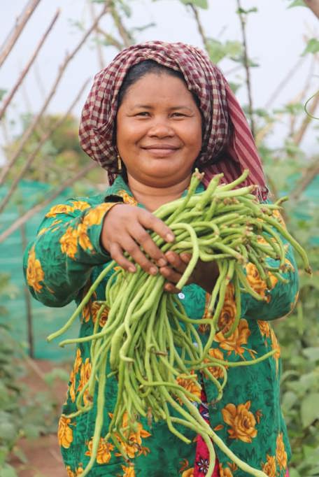 Cambodian Farmer Em Holding Beans In Garden