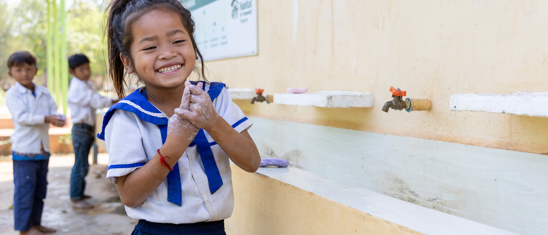 A young girl washing her hands at her school in Cambodia